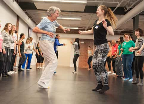 Elderly woman and VCU student dancing together