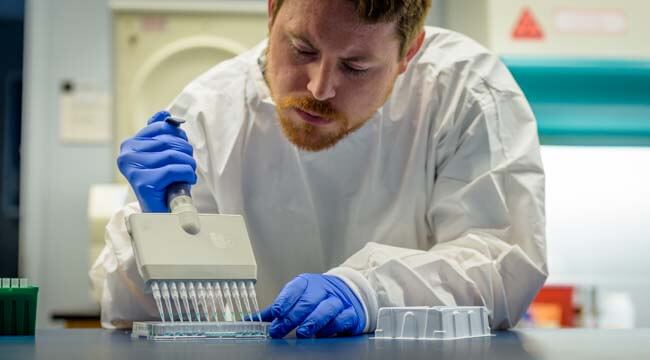 Man in white coat working in lab