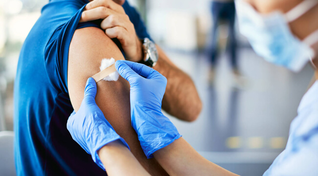 A medical professional puts a bandaid on a person