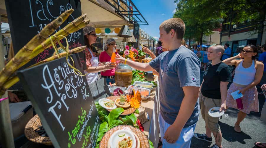 Man reaching for drink at food festival tent