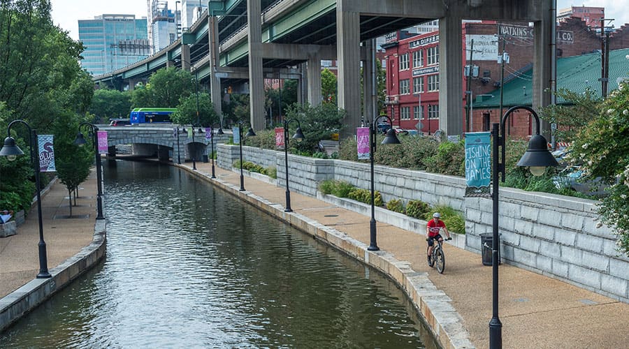 A cyclist rides a bike along the Canal Walk.