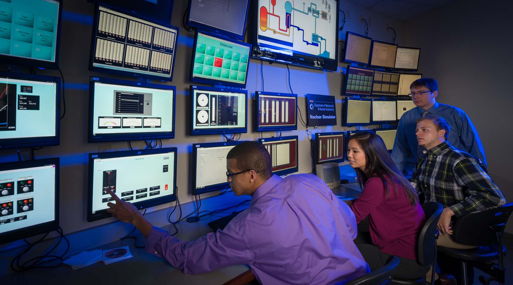 Students in front of wall of computer monitors