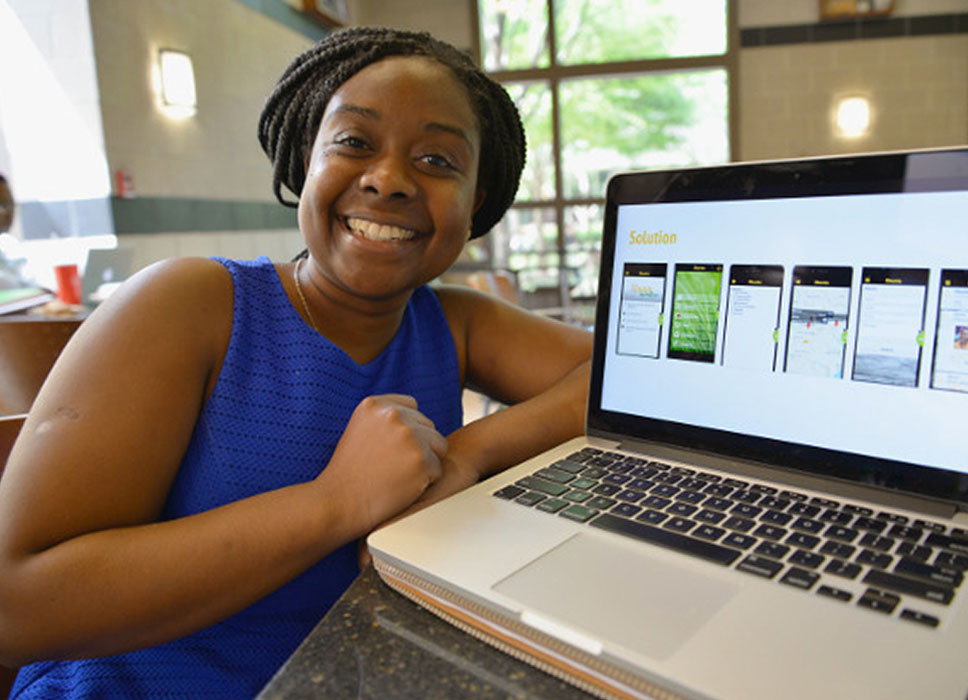 Female student posing with her laptop